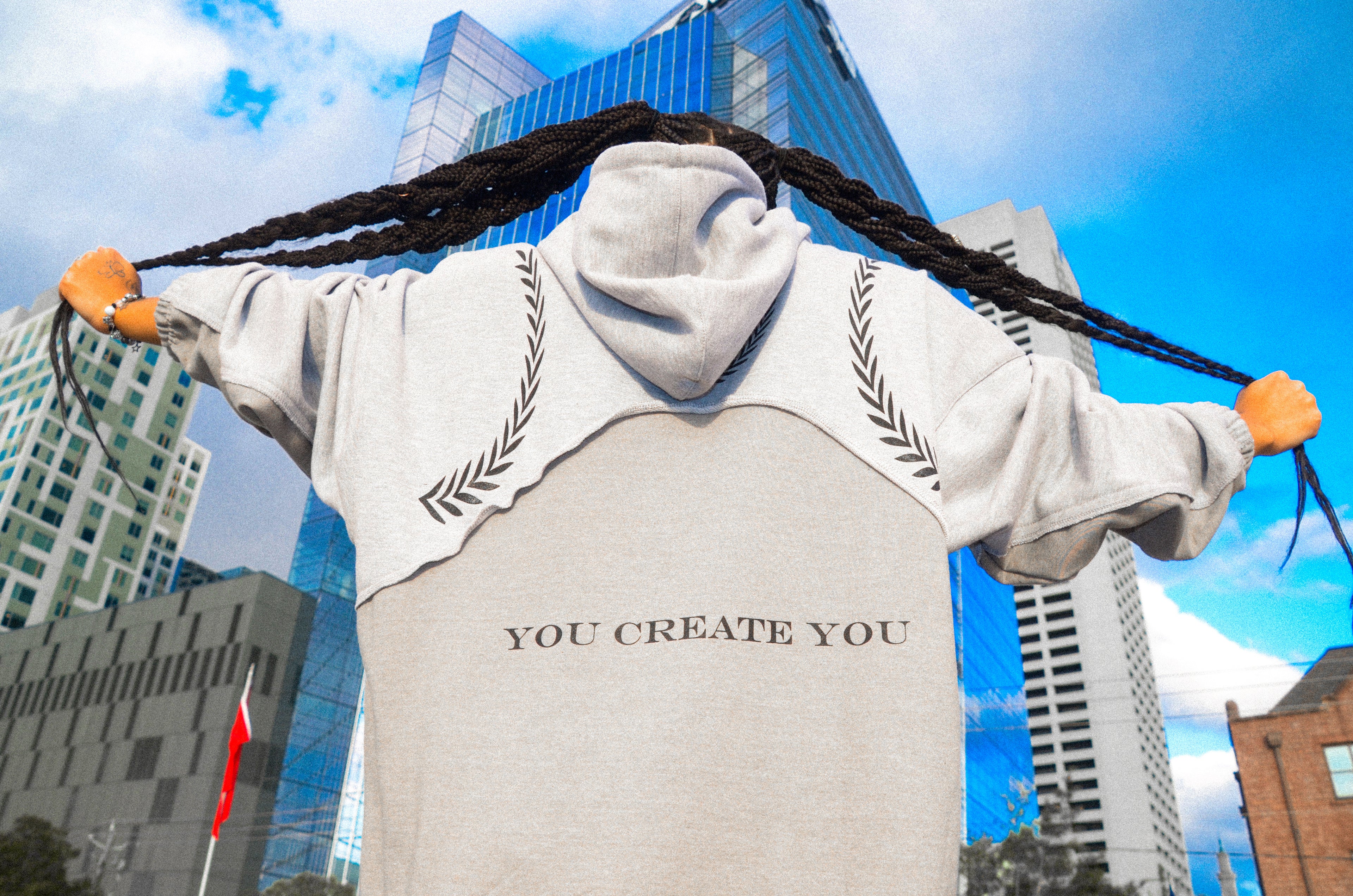 Stylish female model wearing a sleek gray Corbin hoodie, featuring a bold black logo centered on the chest for a modern, minimalist look.