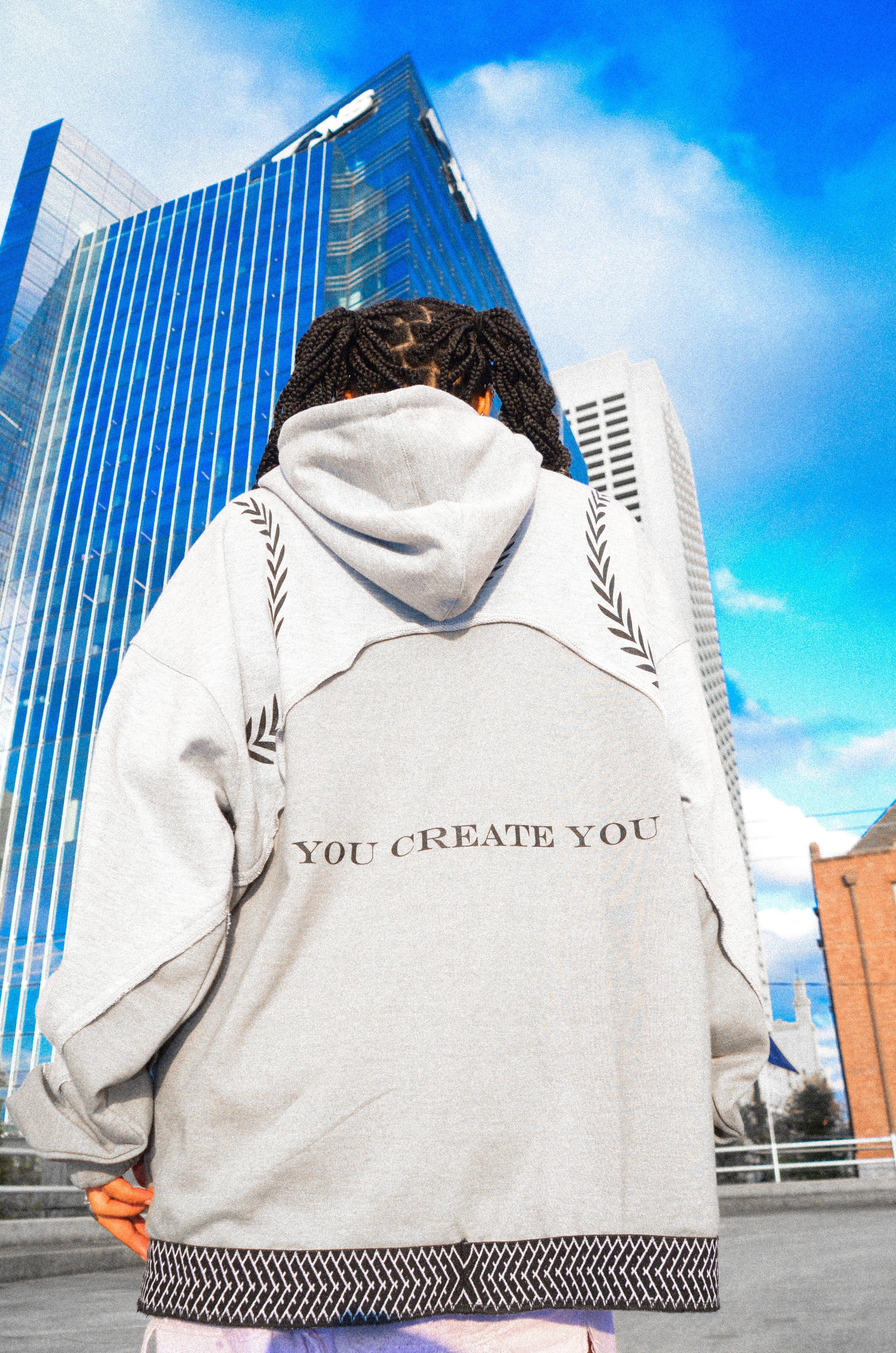 Stylish female model wearing a sleek gray Corbin hoodie, featuring a bold black logo centered on the chest for a modern, minimalist look.